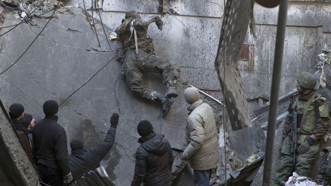 <strong>February 25:</strong> The body of a Ukrainian serviceman is removed from rubble after a battle over the airport in Donetsk, Ukraine.