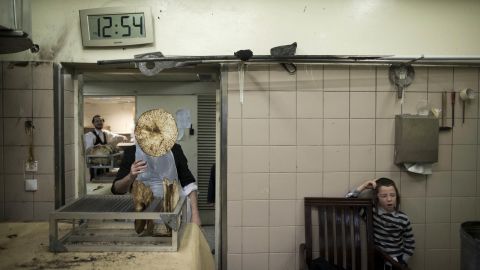 <strong>March 29:</strong> An Ultra-Orthodox Jewish man throws matzo into the air at a bakery in Jerusalem. Matzo, or unleavened bread, is traditionally eaten during the Jewish holiday of Passover.