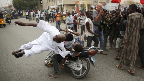 <strong>March 31:</strong> A supporter of Nigerian presidential candidate Muhammadu Buhari is hit by another supporter on a motorbike during celebrations in Kano, Nigeria. Buhari defeated incumbent Goodluck Jonathan.