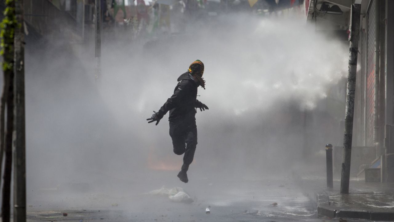 <strong>May 1:</strong> A masked protester runs away as police use water cannons on May Day demonstrators in Istanbul. Clashes erupted between police and protesters who defied a government ban on marching to Taksim Square. <a href="http://www.cnn.com/2015/05/01/world/gallery/may-day-pictures-2015/index.html" target="_blank">May Day</a> is referred to as International Workers' Day in many countries.