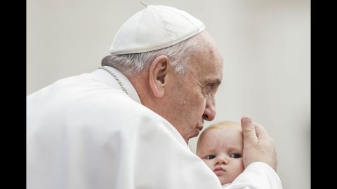 <strong>October 7: </strong>Pope Francis kisses a child at St. Peter's Square in the Vatican.