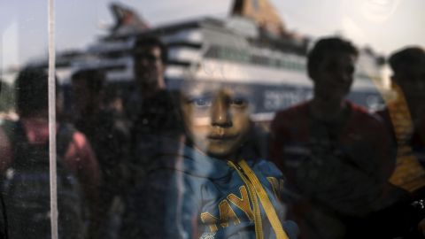 <strong>October 19:</strong> A young boy is seen through a bus window as refugees and migrants arrive at the port of Pireaus, Greece. 