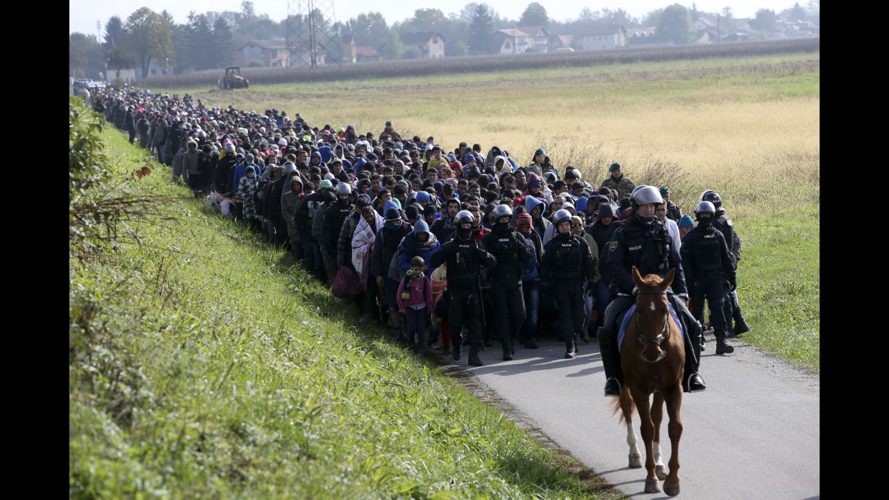 <strong>October 20:</strong> A mounted police officer leads a group of migrants near Dobova, Slovenia. Thousands of migrants flooded into the country from Croatia after Hungary sealed off its border.