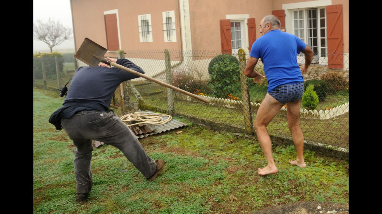 <strong>November 9:</strong> A member of the Bird Protection League, left, is hit by a spade thrown by the owner of a plot where finch traps were found in Audon, France. Wildlife activists were trying to disable the traps.