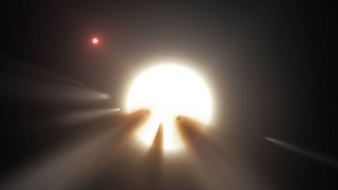 This illustration, created based on data from Spitzer and the Kepler Space Telescopes, shows a star behind a shattered comet, which creates an anomaly in space. 