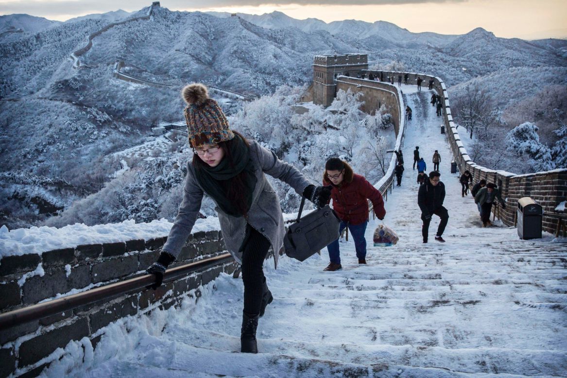 Tourists cautiously climb the slippery steps of the Great Wall after an early-season snowfall on November 23 near Beijing.
