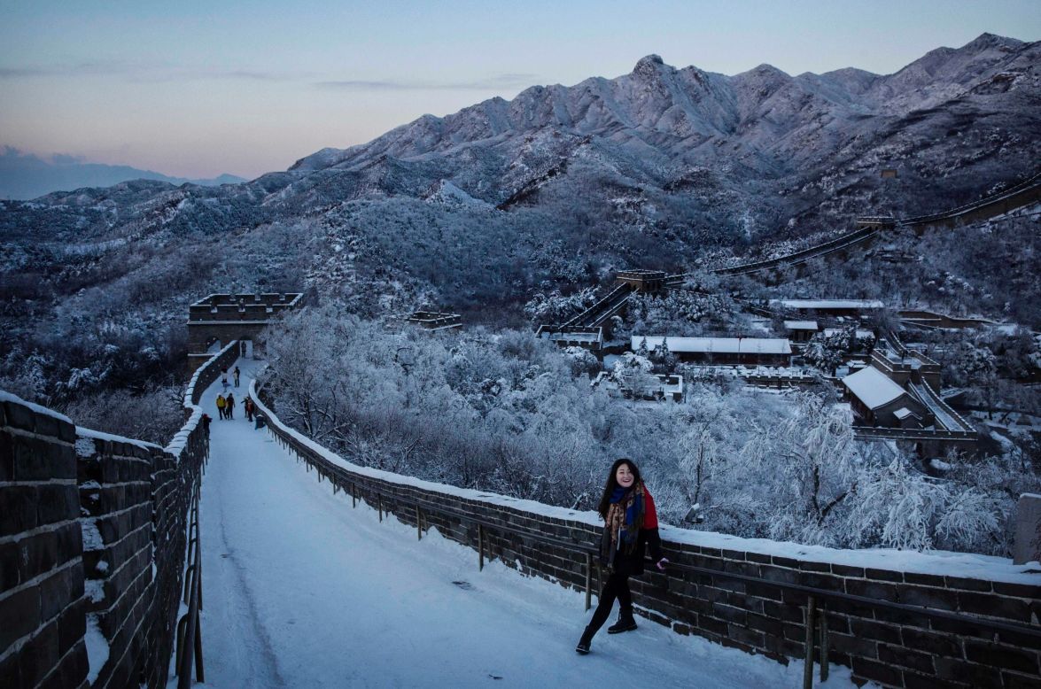 Smiling, a Chinese tourist takes a break as she works her way through a slippery section of ice on the Great Wall near Beijing on November 23.