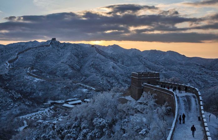 The sun lights up the otherwise blue overtones of the Great Wall and landscape blanketed in snow near Beijing on November 23.