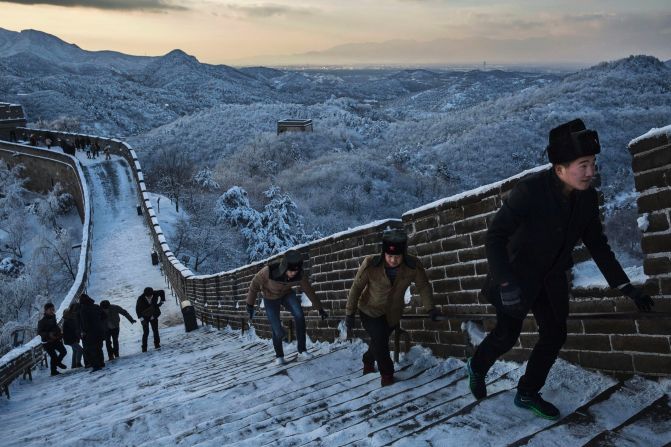 Staying warm in retro fur hats bearing the communist red star, visitors take on a steep and snowy section of the Great Wall near Beijing on November 23.