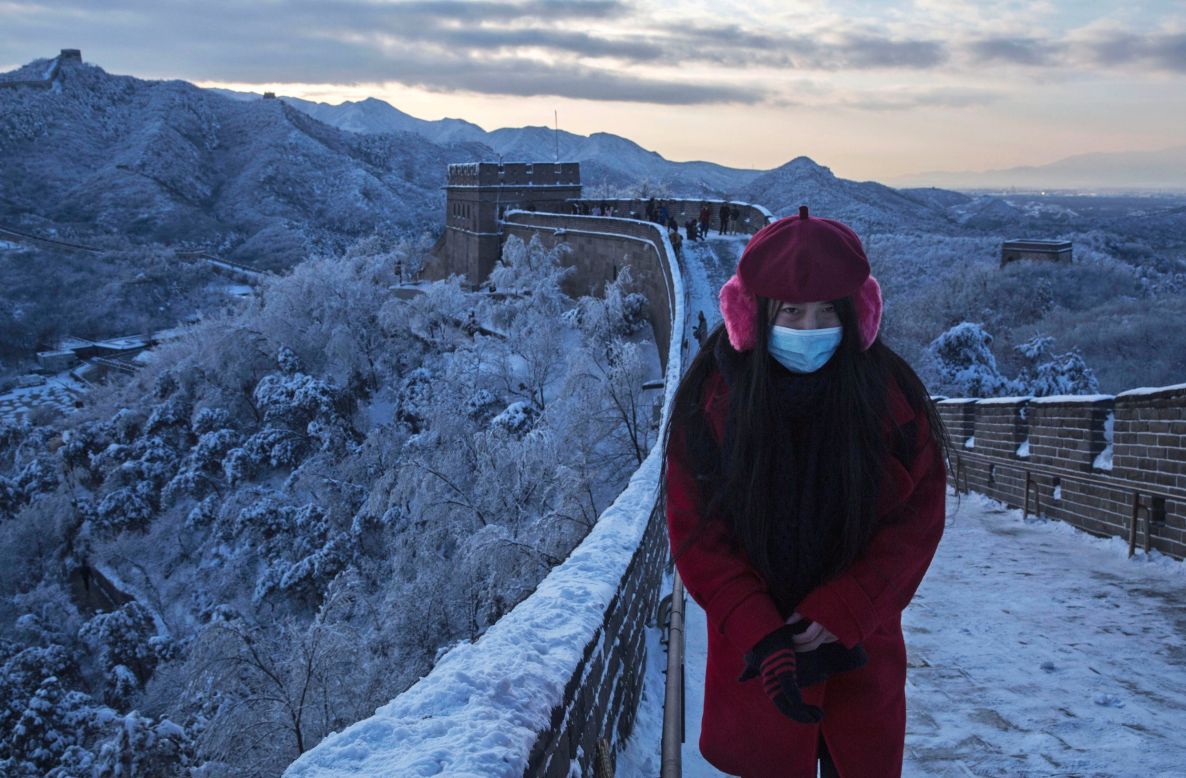 A Chinese tourist poses on a slippery section of ice as snow is seen on the Great Wall on November 23 near Beijing, China.