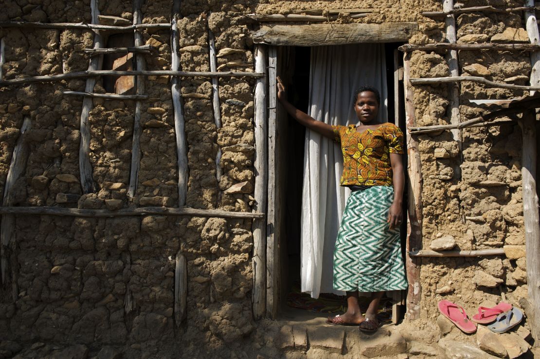 Christina, 14, outside her house where she lives with her husband and  mother-in-law in Tanzania. She was married at 13. 
