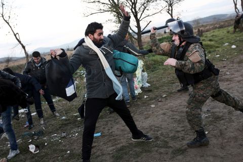 A Macedonian police officer hits a man with his baton near Idomeni at the Greek-Macedonian border -- this is part of the so-called Balkans Route to northern Europe. 