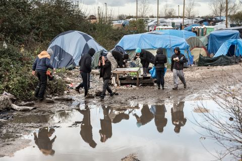 Migrants and refugees in the migrant camp known as the "Jungle" near the northern French port of Calais where some 4,500 people live. 