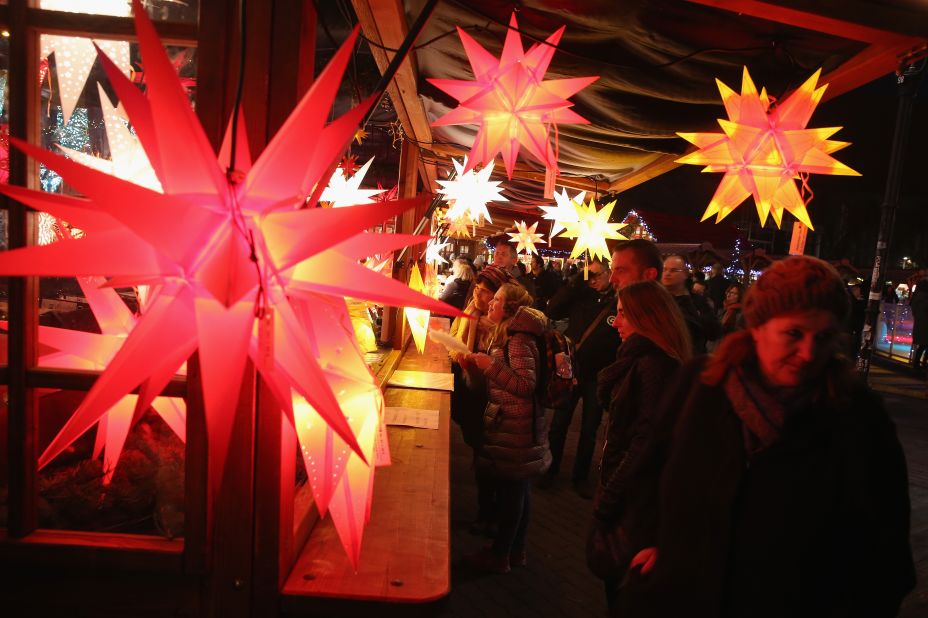 Visitors walk past a stall selling illuminated stars at the annual Christmas market at Alexanderplatz in Berlin.