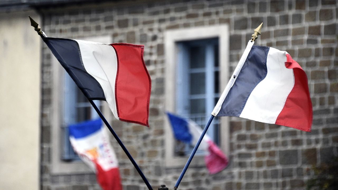 A picture taken on November 27, 2015, shows French national flags put on a window and in the streets in Hede-Bazouges, north of Rennes, during the National Tribute to the 130 people killed in the November 13 Paris attacks. President Francois Hollande will lead a solemn ceremony in honour of the victims. Families of those killed in France's worst-ever terror attack, claimed by the Islamic State (IS) group, will join some of the wounded at ceremonies at the Invalides, the gilded 17th-century complex in central Paris that houses a military hospital and museum and Napoleon's tomb.The tribute will be "National and Republican," an official at the Elysee presidential palace said, referring to the French republic's creed of liberty, equality and fraternity. AFP PHOTO / DAMIEN MEYER / AFP / DAMIEN MEYER        (Photo credit should read DAMIEN MEYER/AFP/Getty Images)