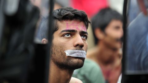 A man tapes his mouth shut in protest, after being told to turn back in Gevgelija, Macedonia