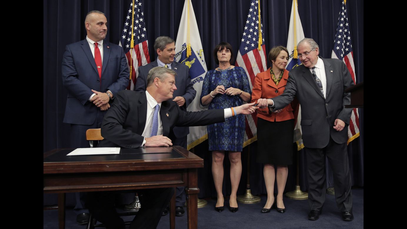 Massachusetts Gov. Charlie Baker hands a pen to House Speaker Robert DeLeo after signing a bill at the State House in Boston on Tuesday, November 24. The legislation adds criminal penalties for trafficking fentanyl, a powerful drug that law enforcement officials say is often added to heroin. 