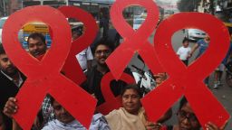 Indian volunteers and the members of a social organisation holds ribbon shaped placards for an HIV/AIDS awareness messages during rally  in Kolkata on November 30, 2012, on the eve of World AIDS Day. The UNAIDS agency says some 2.5 million Indians are living with HIV, many of them ostracised by their communities. AFP PHOTO/Dibyangshu SARKAR        (Photo credit should read DIBYANGSHU SARKAR/AFP/Getty Images)