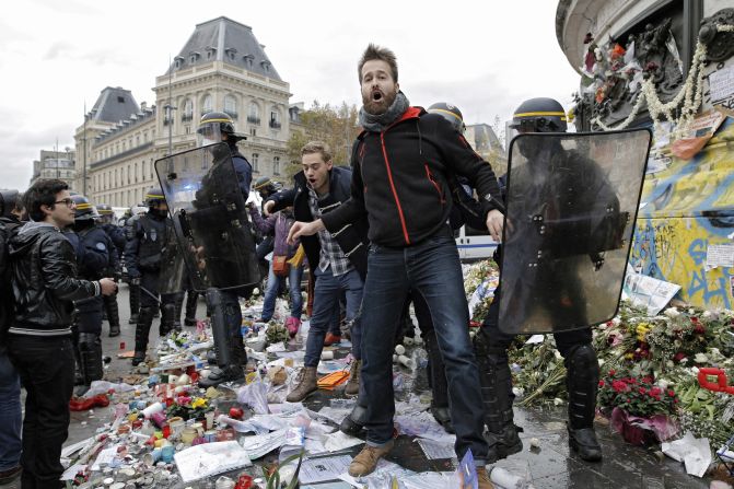 A man is detained November 29 by police at the Place de la République, where the candles and flowers were set in memory of the victims of the Paris terror attacks earlier in the month.