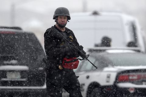 Colorado Springs police officers search the area near the scene.