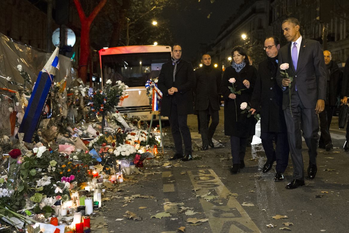 President Barack Obama, French President Francois Hollande, second from right, and Paris Mayor Anne Hidalgo arrive at the Bataclan, site of one of the Paris terrorists attacks, to pay their respects to the victims after Obama arrived in town for the COP21 climate change conference early on Monday, November 30, in Paris. 