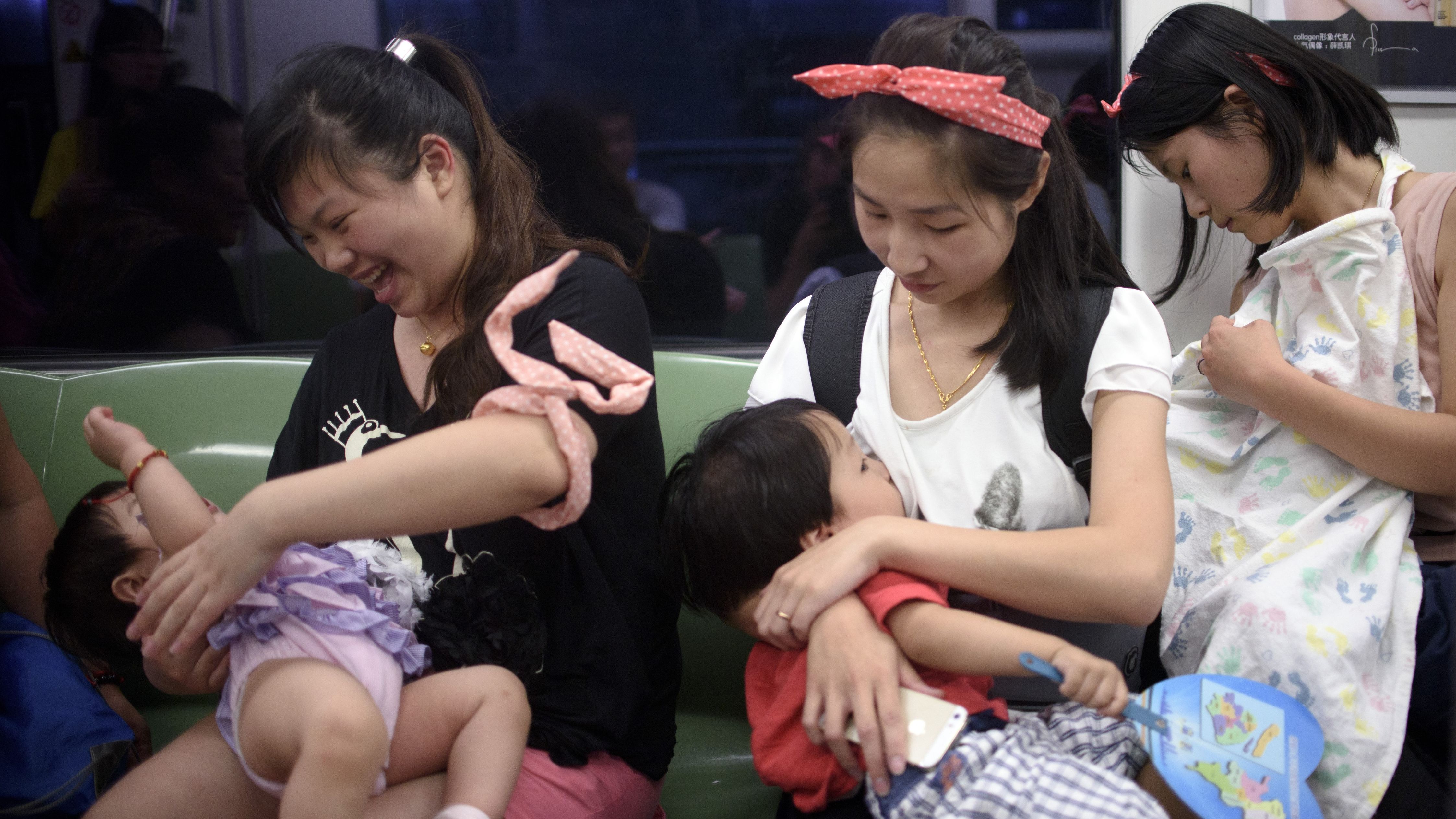 Mothers breastfeed their babies in a Beijing subway during an event celeberating the World Breastfeeding Week on August 1, 2015.  