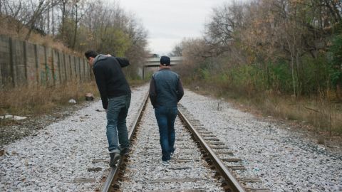 Graffiti artist Trevor Timm, right, walks with a friend along train tracks on the north side of the city, toward a bridge where Timm often paints.