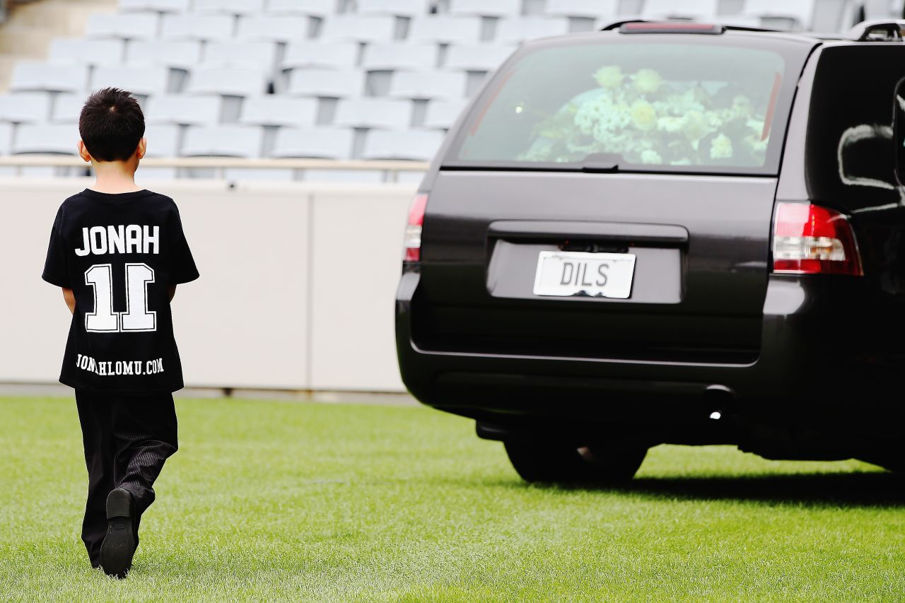 Lomu's son Dhyreille follows the hearse carrying his late father as it leaves the stadium.