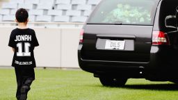 Jonah Lomu's son Dhyreille walks behind the hearse carrying his father's body