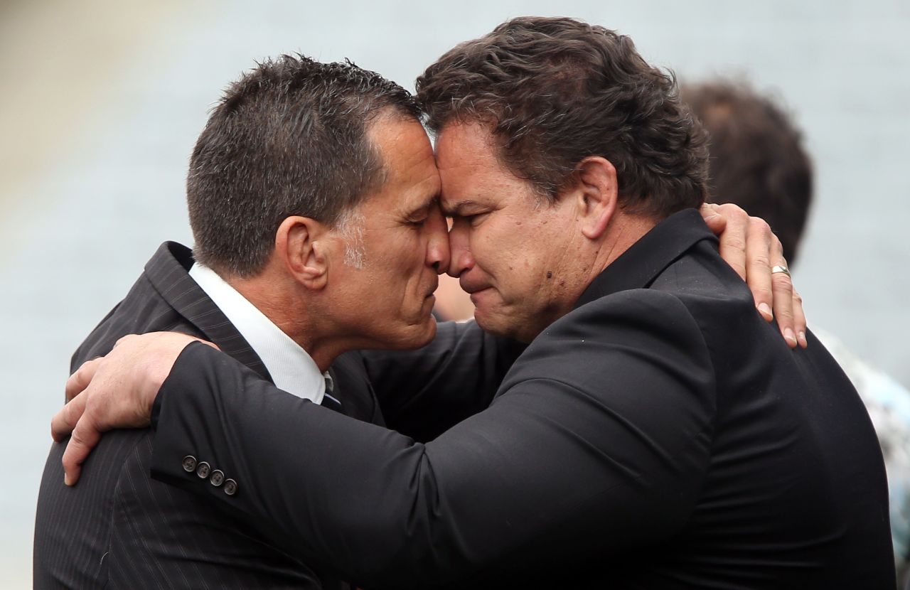 Former All Blacks Dalls Seymour (L) and Michael Jones perform a traditional Maori "hongi" greeting after the memorial service.
