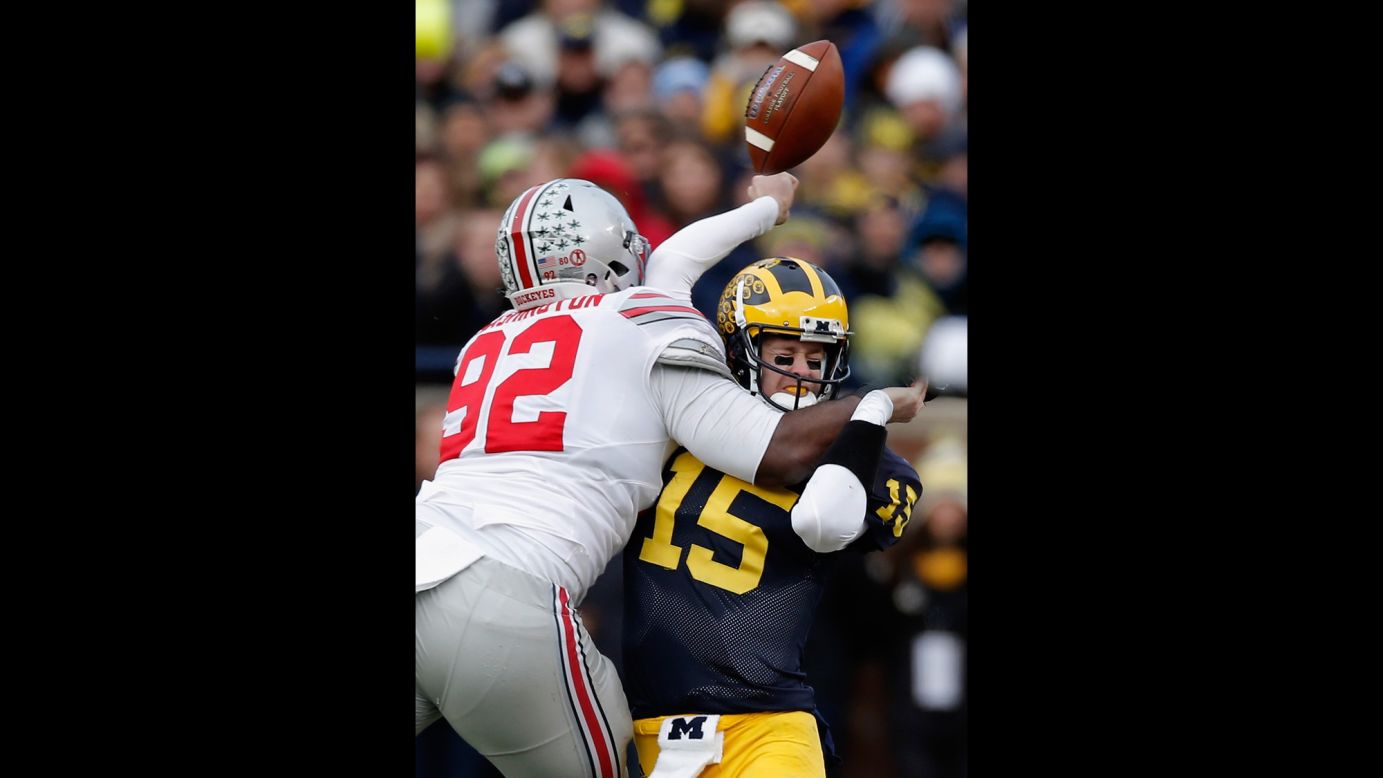 Michigan quarterback Jake Rudock fumbles the ball as he's hit by Ohio State's Adolphus Washington during a college football game played Saturday, November 28, in Ann Arbor, Michigan. Ohio State hammered its rival 42-13.