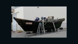 This picture taken on November 24, 2015 shows coast guard officials investigating a wooden boat at the Fukui port in Sakai city in Fukui prefecture, western Japan after the ship was found drifting off the coast of Fukui. Japan is investigating nearly a dozen suspicious boats recently found drifting off the country's coastline, some with decaying bodies aboard, officials said on November 27, as media speculated they came from North Korea. At least 11 cases involving wooden boats -- some badly damaged -- with 20 bodies on board have been reported during October and November.   