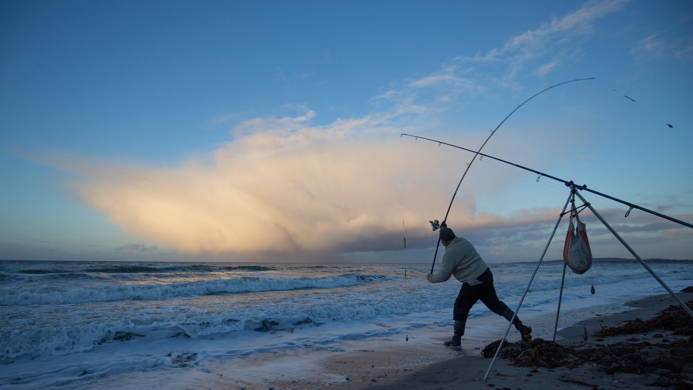 An angler casts his reel during a fishing competition near Weissenhaeuser Strand, Germany, on Saturday, November 28.