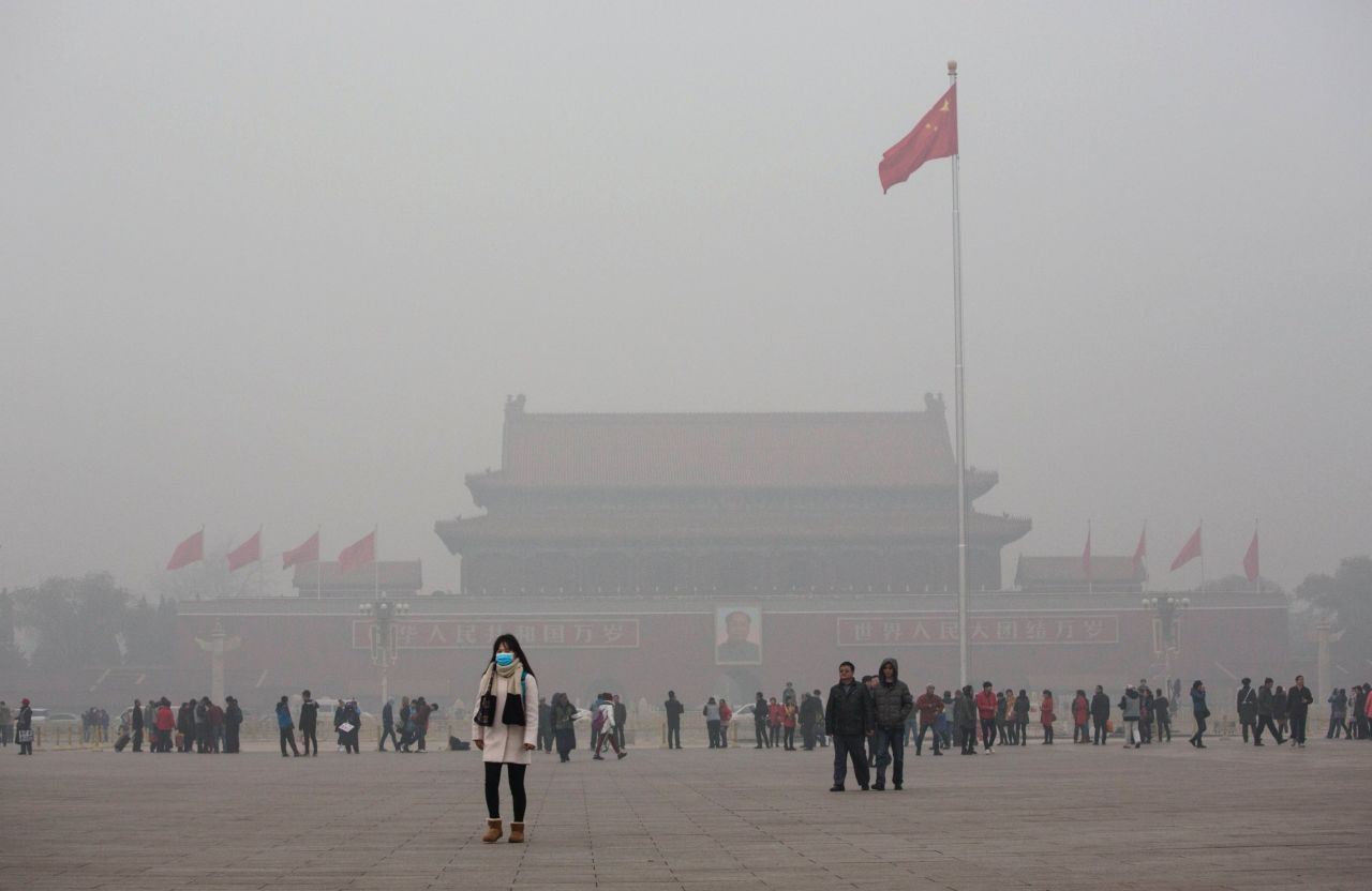 A Chinese woman protects herself with a mask as she walks past Tiananmen Square in smog-hit Beijing on November 30, 2015. Levels of PM 2.5, considered the most hazardous pollutant, crossed 600 units in Beijing, nearly 25 times the acceptable standard set by the World Health Organization. 