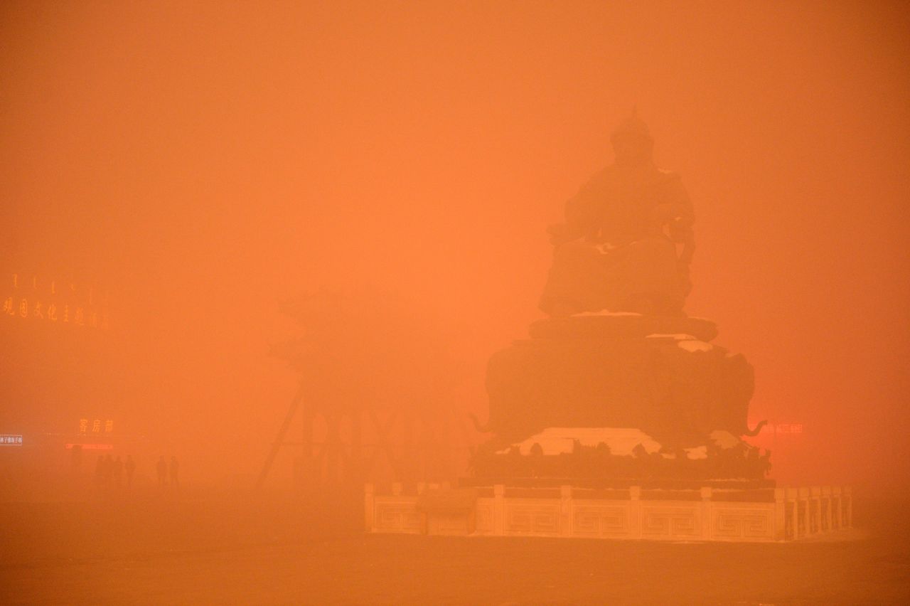 A Genghis Khan statue is obscured by a cloak of orange-tinged smog on November 29, 2015 in Hohhot, capital of Inner Mongolia, China.
