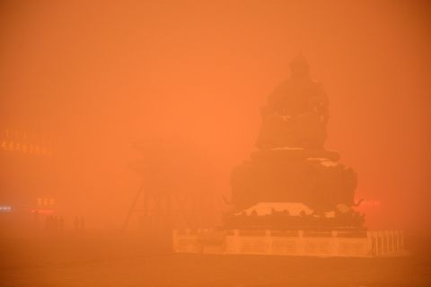 A Genghis Khan statue is obscured by a cloak of orange-tinged smog on November 29, 2015 in Hohhot, capital of Inner Mongolia, China.
