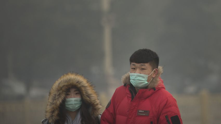 In this Saturday, Nov. 28, 2015, file photo, people wearing face masks walk across Tiananmen Square on a day with poor air quality in Beijing. Air pollution in Beijing reached hazardous levels on Saturday as smog engulfed large parts of the country despite efforts to clean up the foul air.