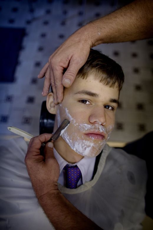 The chess genius has had to grow up under the public eye. Here, the 19 year old looks on while being shaved at a barbers shop in Oslo in 2009. 