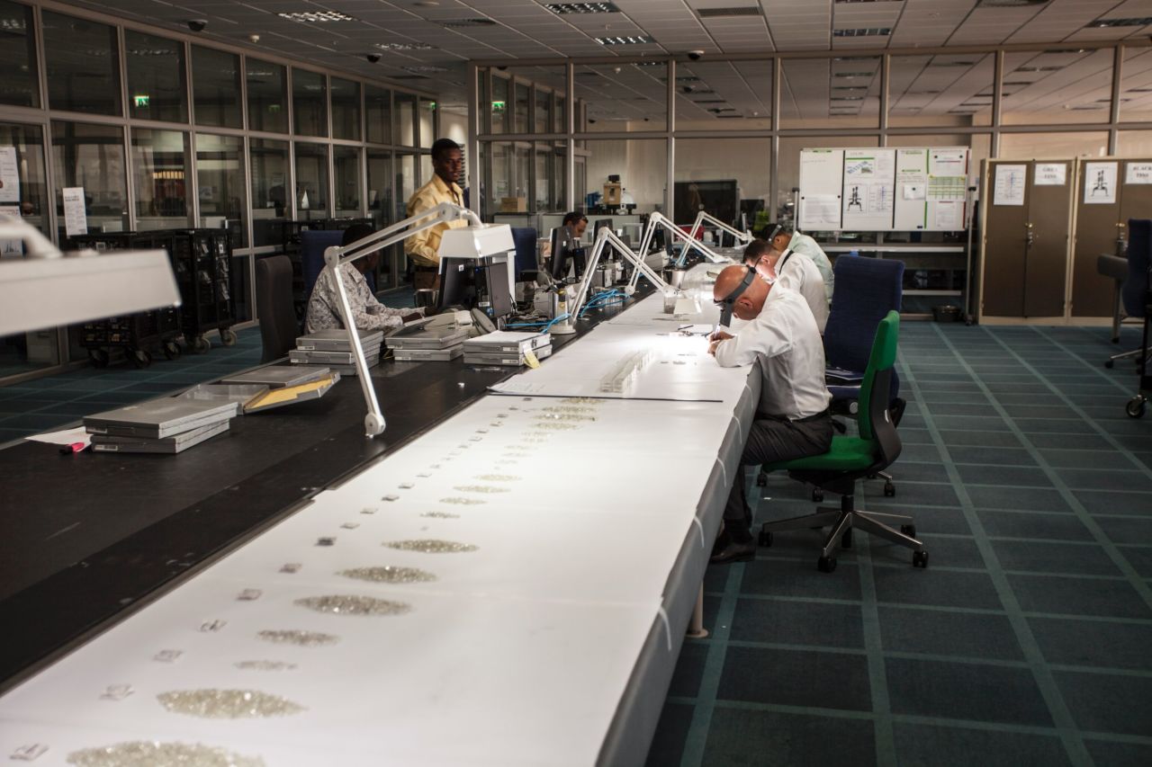 De Beers employees inspect diamonds aggregated from the company's global supply in Gaborone, Botswana. The company moved 82 experts and their families from London to set up the facility in 2013.