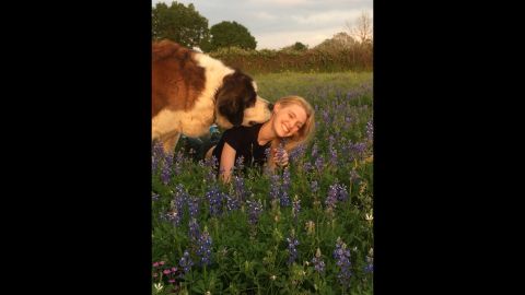 Before her treatment, Sarah was confined to a life inside the house or a hospital room. Now, she is more active and spends as much time outside as she can. She's pictured here with Big Ben, her therapy dog. 