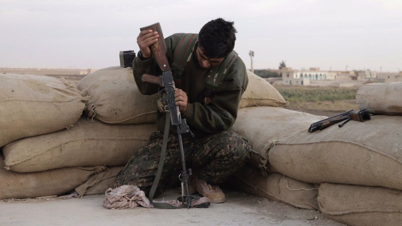 A Kurdish soldier cleans his weapon.