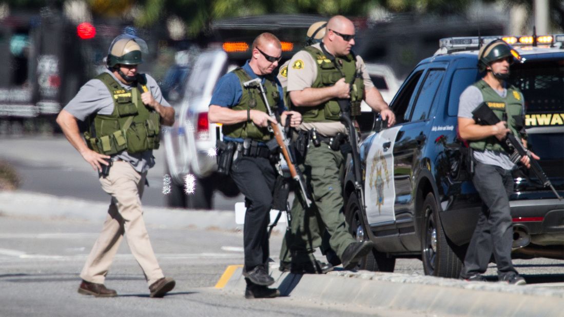 Police in SWAT gear secure the area.