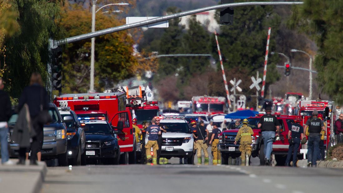 Police and fire personnel are seen near the site of the shooting.