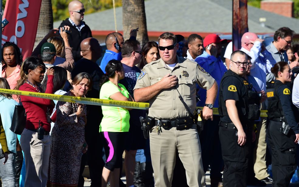 A crowd gathers behind the police line.