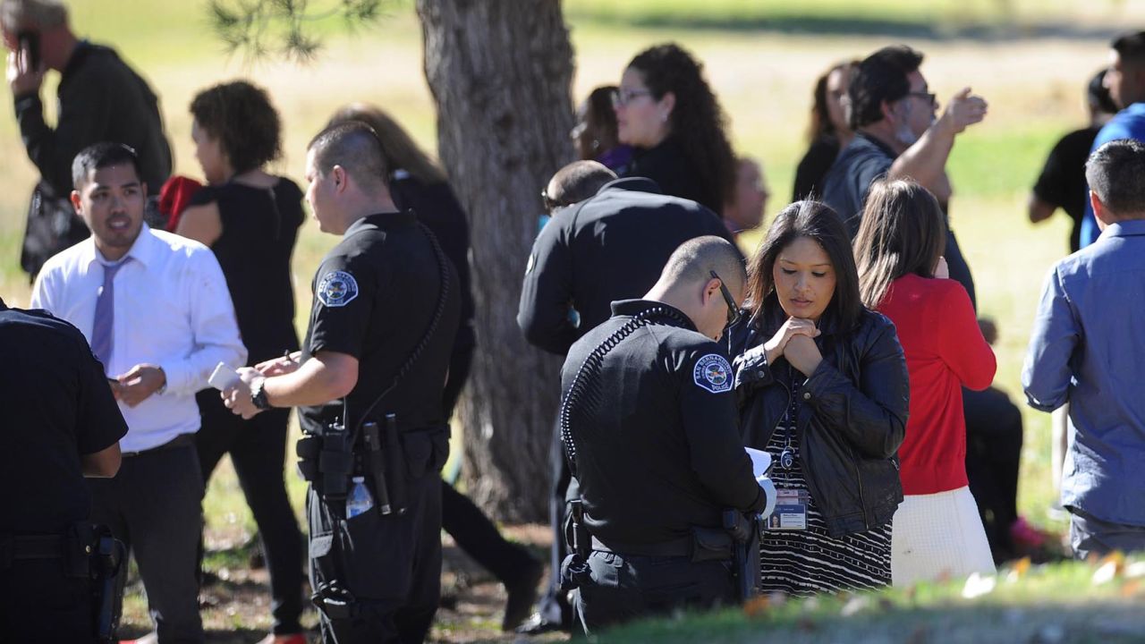People gather at San Bernardino Golf Course after being evacuated from the scene after the shooting.