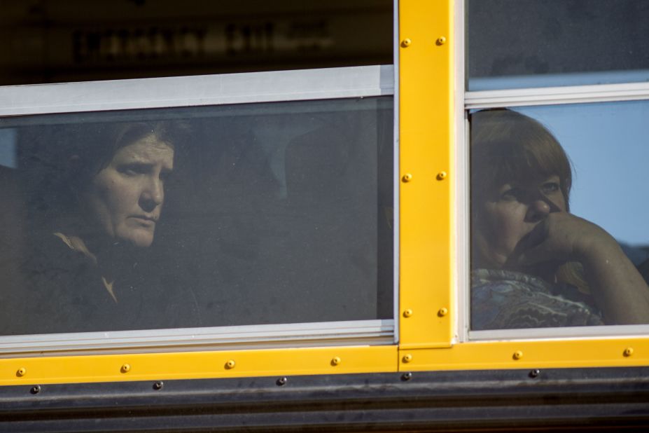 People are moved away from the area by bus.