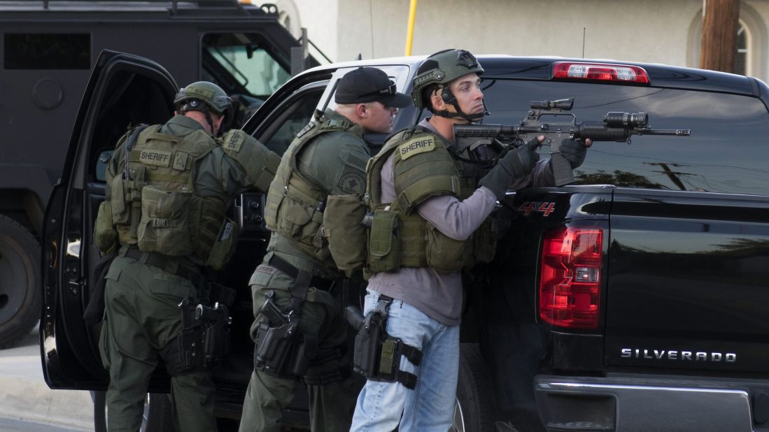 Law enforcement officers search a neighborhood in San Bernardino.