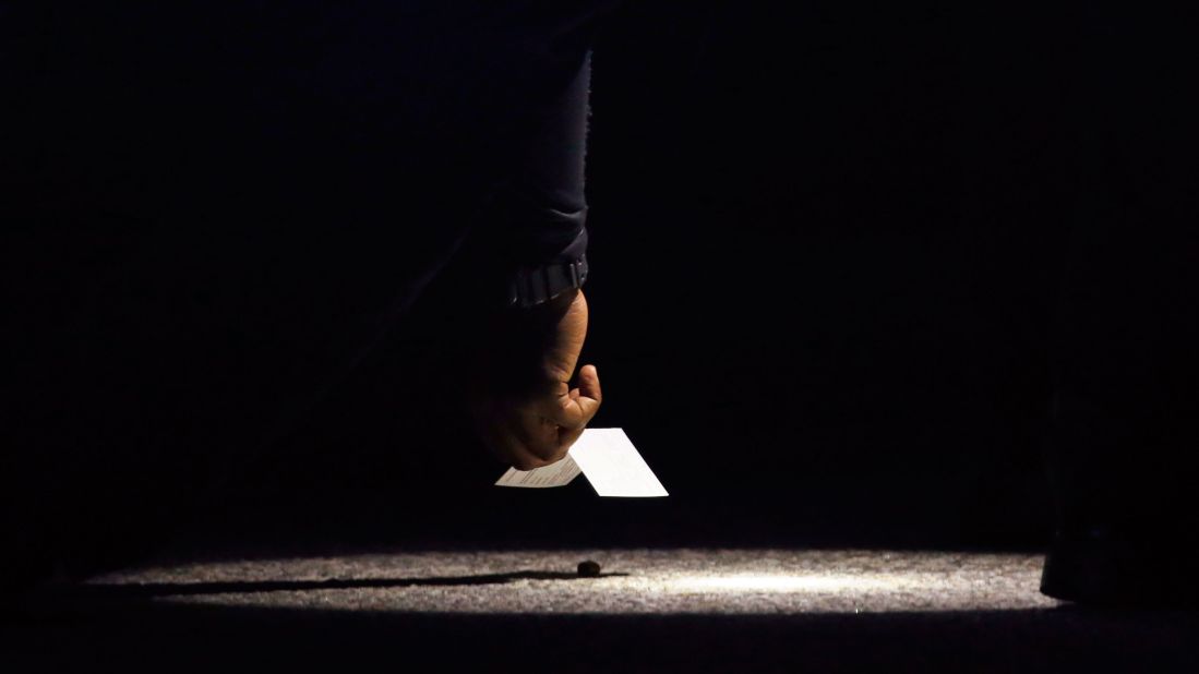 A police officer places a marker along East San Bernardino Avenue, near where the shootout occurred.