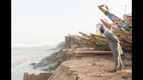 Rybus' photo series focuses on the effects of climate change on two communities: the coastal community of fishermen and the inland community of herders and farmers. Here, a businessman assesses the damage along the crumbling coast.