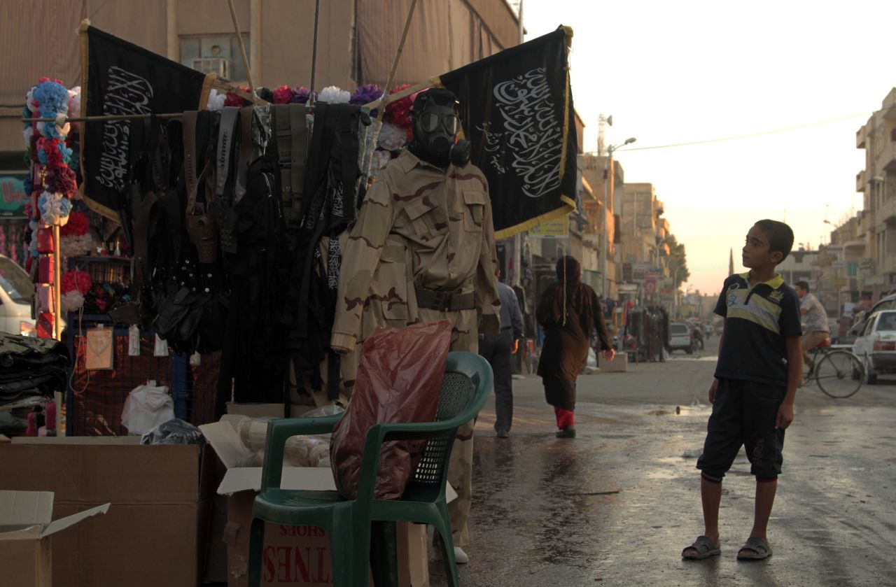 A child looks at a stand selling military fatigues in Raqqa on October 1, 2013. Many in Raqqa say they don't want to live under ISIS but have no choice.